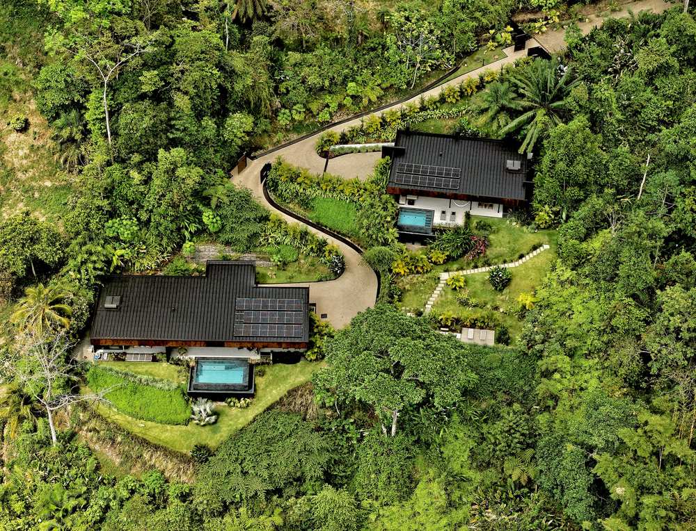 Black House Villas seen from the air, two architect-designed residences set into a planted hillside above Ballena