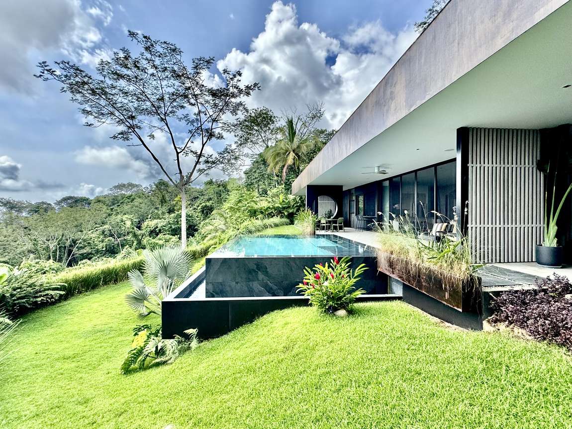 The villa and pool seen across the lawn