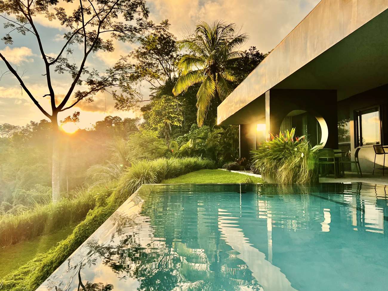 The pool at sunset, lit under the cantilevered roof