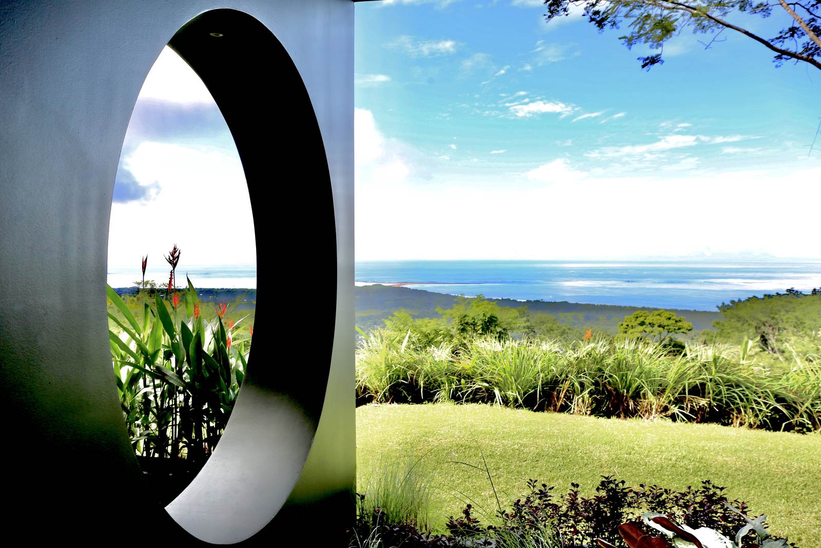 A round window cut through the wall, framing the coast