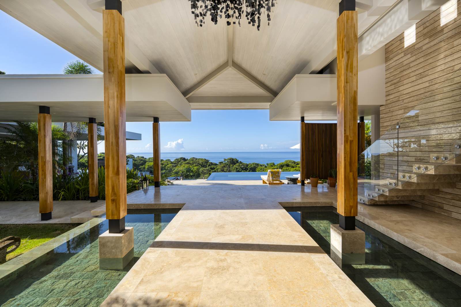 Casa Belmer, its 14-meter infinity lap pool framed by timber columns above the Dominical coast