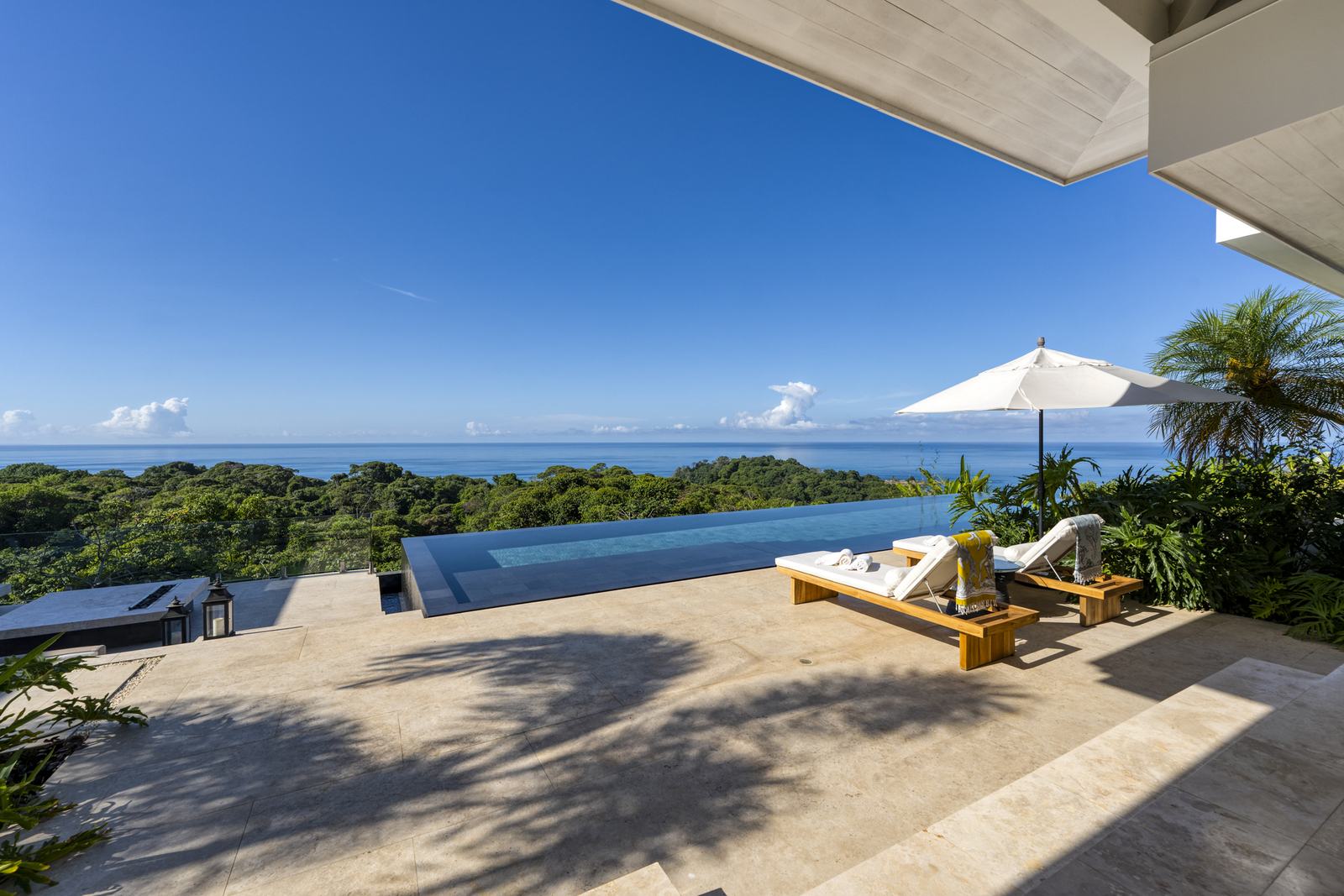 Shade and loungers on the terrace above the water