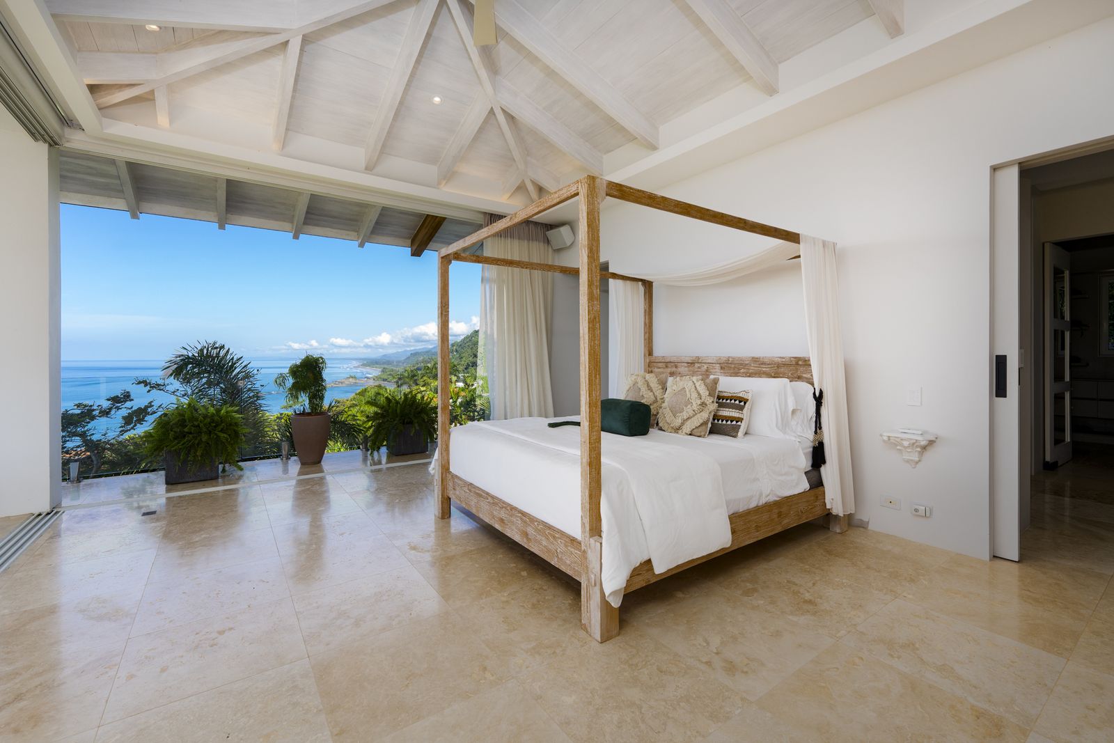 A master suite with a four-poster bed and ocean view
