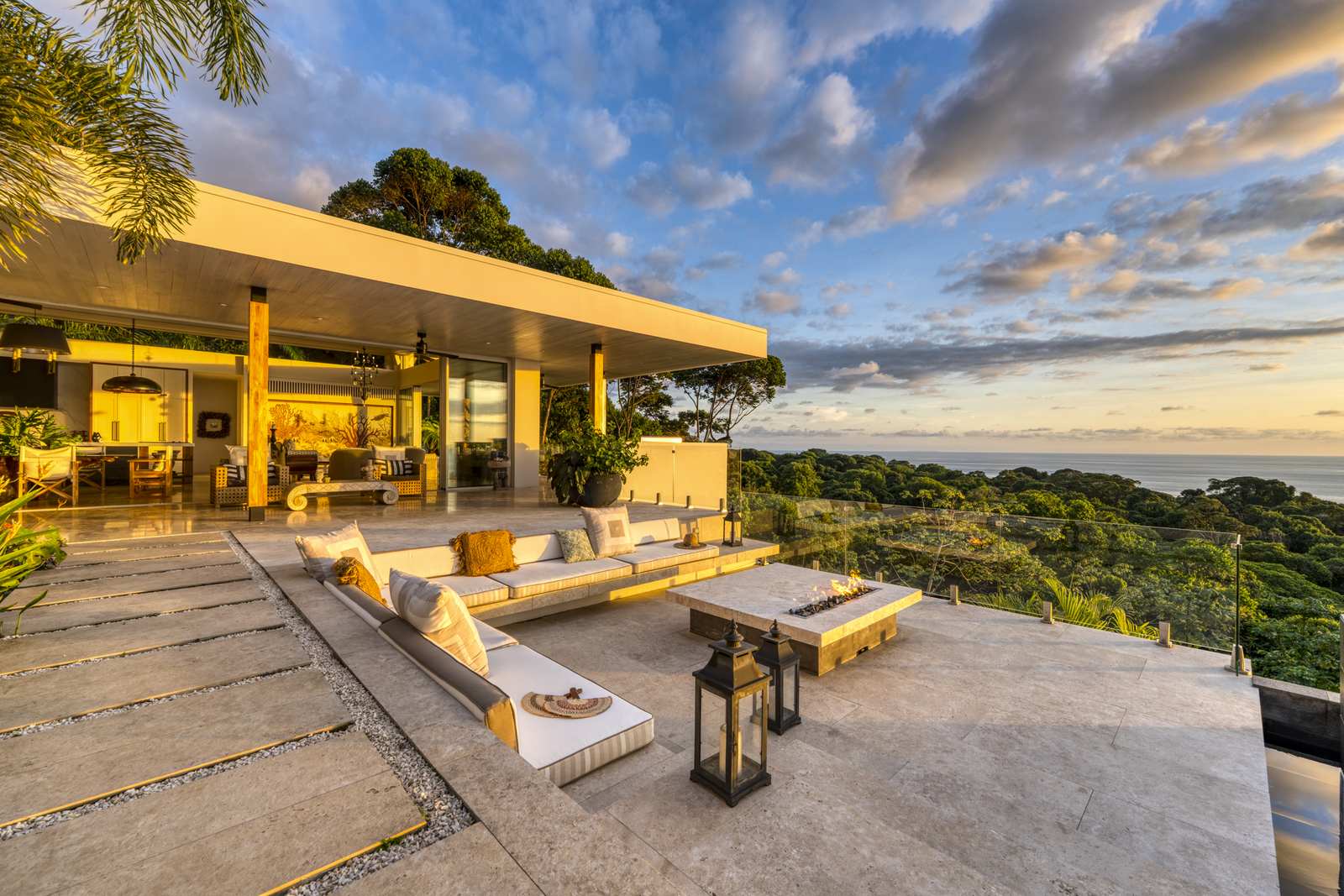 The terrace lit at dusk, the ocean beyond