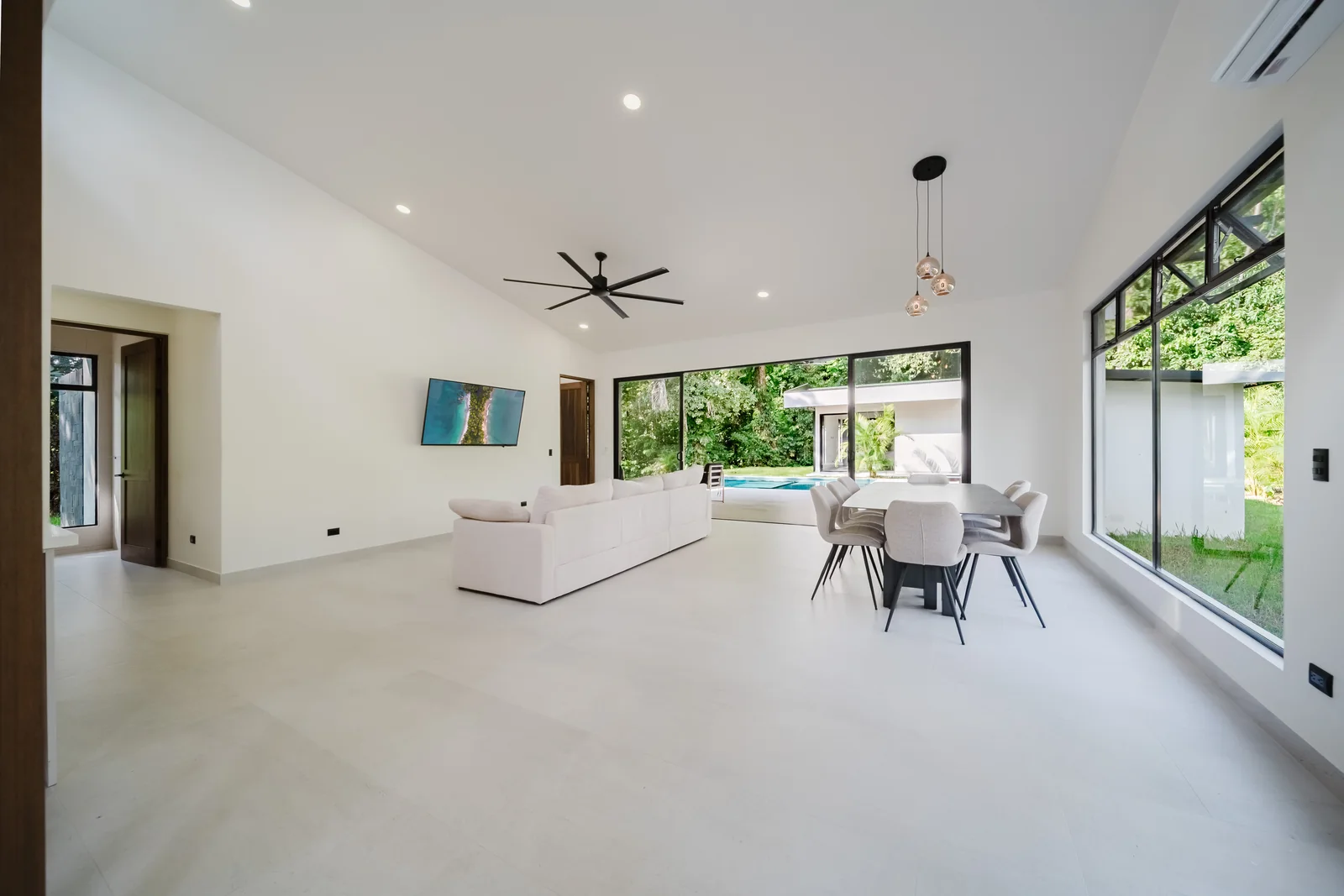 Casa Escondida &mdash; the living room, opened to the pool through full-height glass