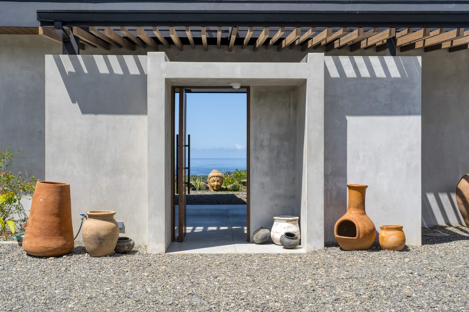 Casa Karuna &mdash; The entrance, with earthenware pots against the rendered wall