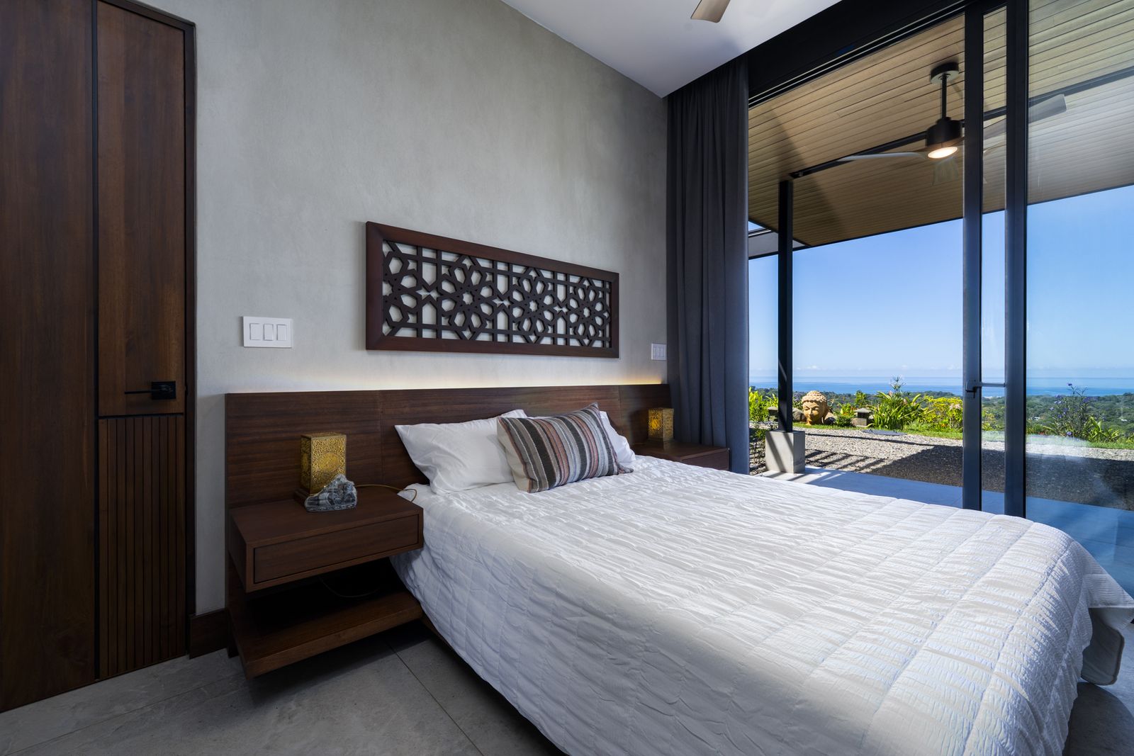Casa Karuna &mdash; A bedroom with a carved timber headboard panel
