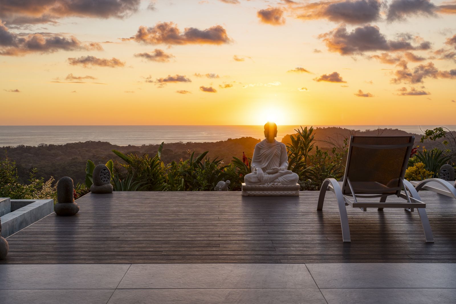 Casa Karuna &mdash; A stone Buddha on the deck at sunset