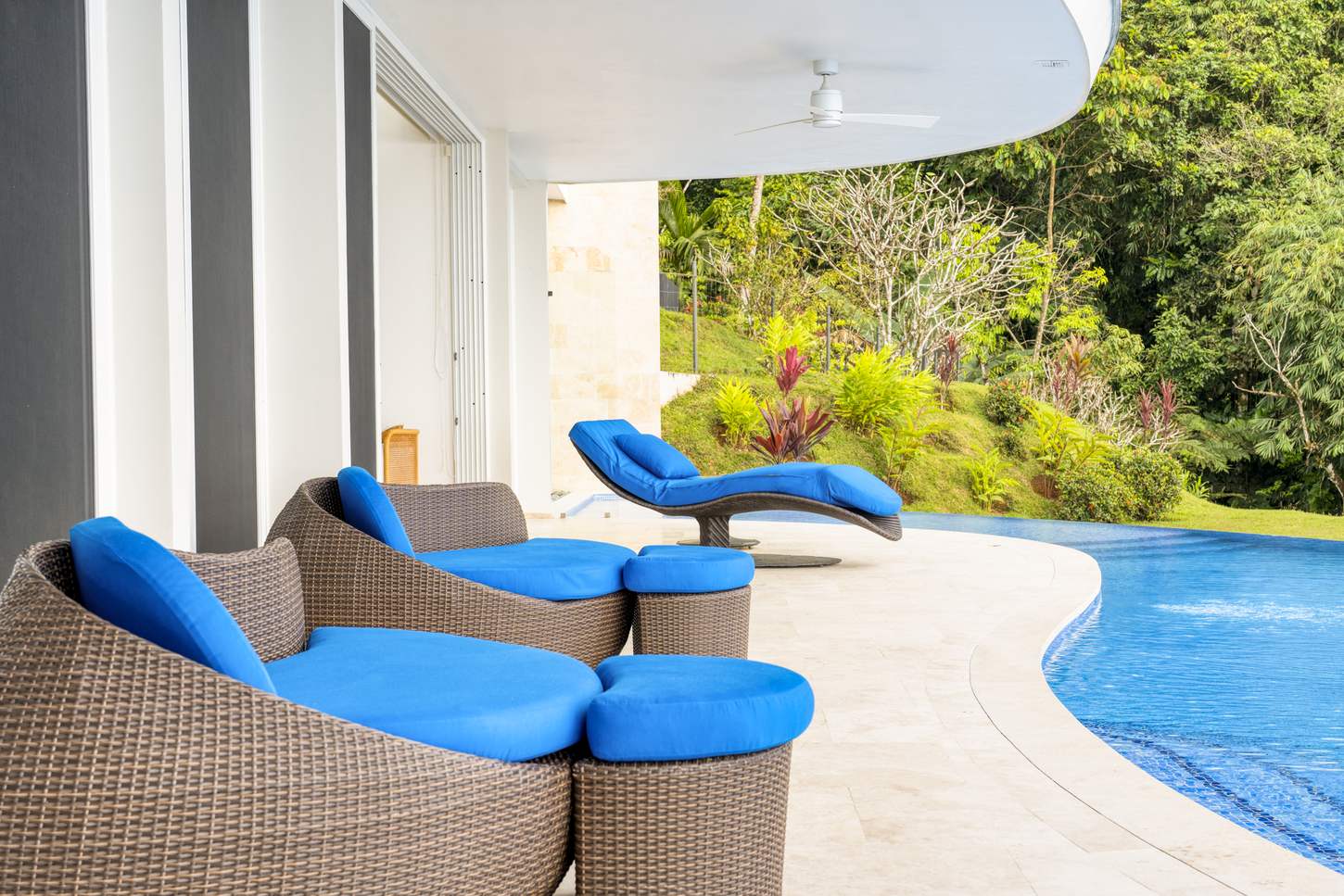 Loungers at the pool's edge, facing the coast