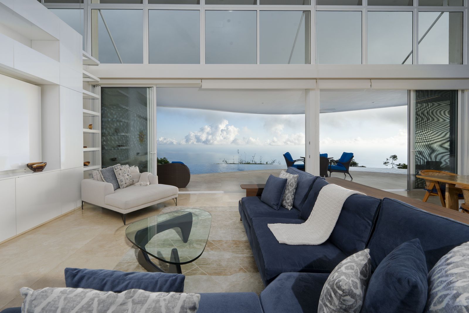 The main living room, its glass wall opened to the ocean