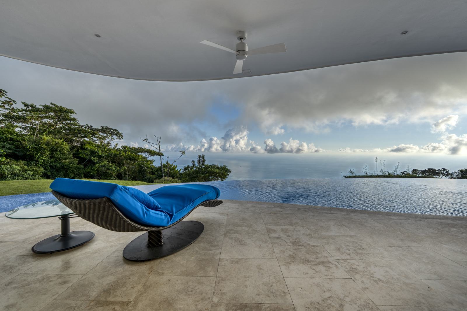 A chaise drawn up to the glass wall above the canopy