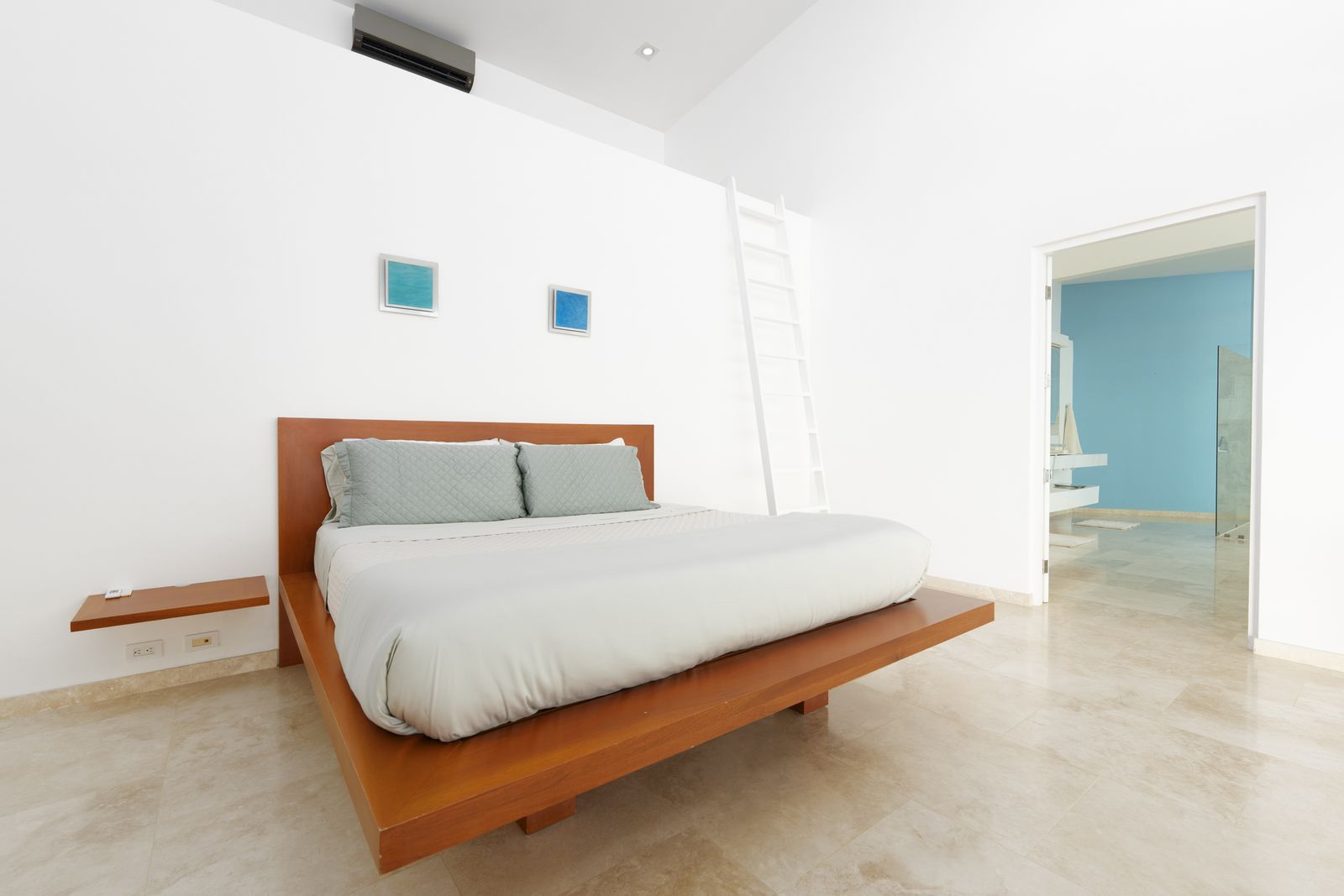 A bedroom with a blue accent wall and a wall of glass