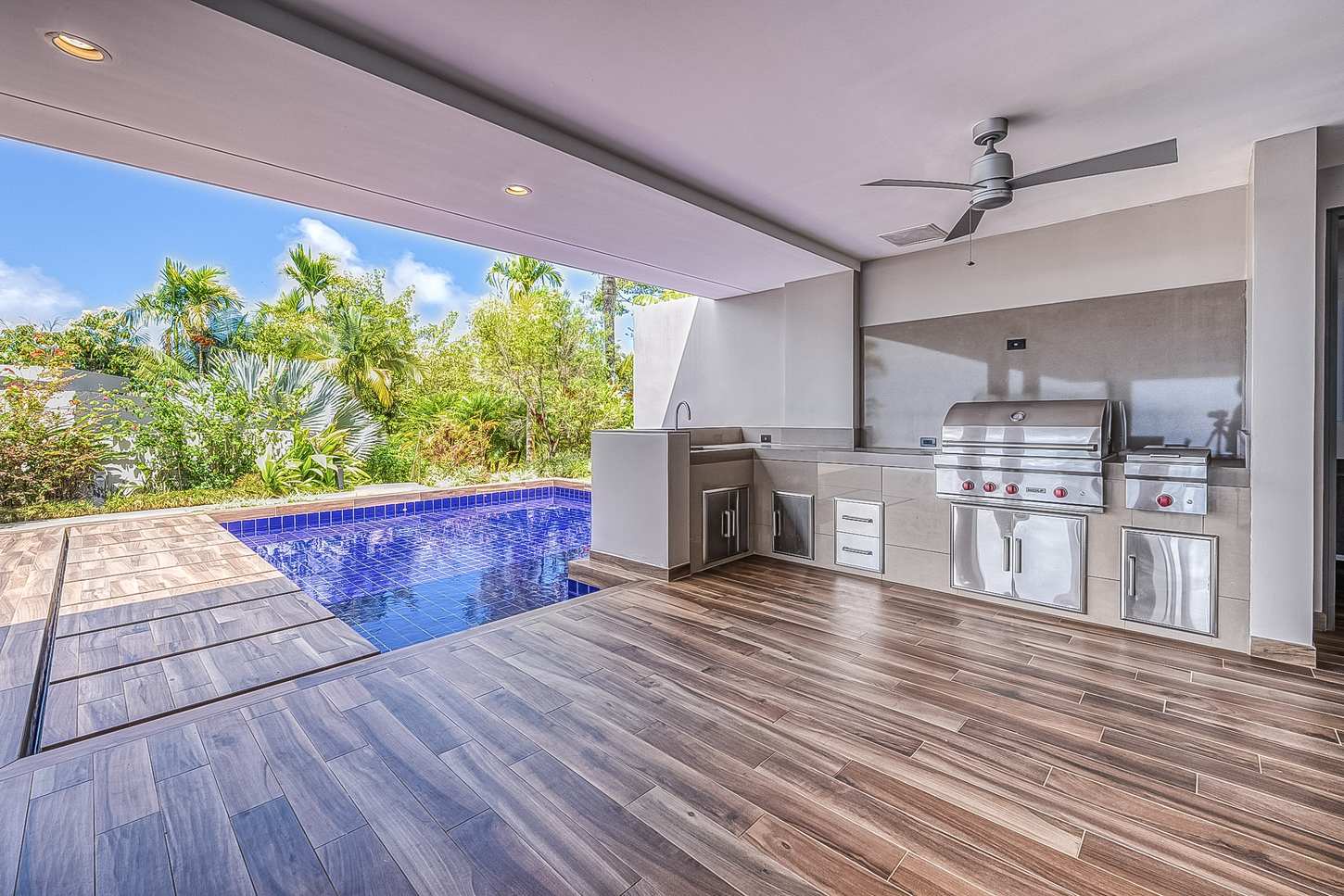 The covered terrace and outdoor kitchen alongside the pool