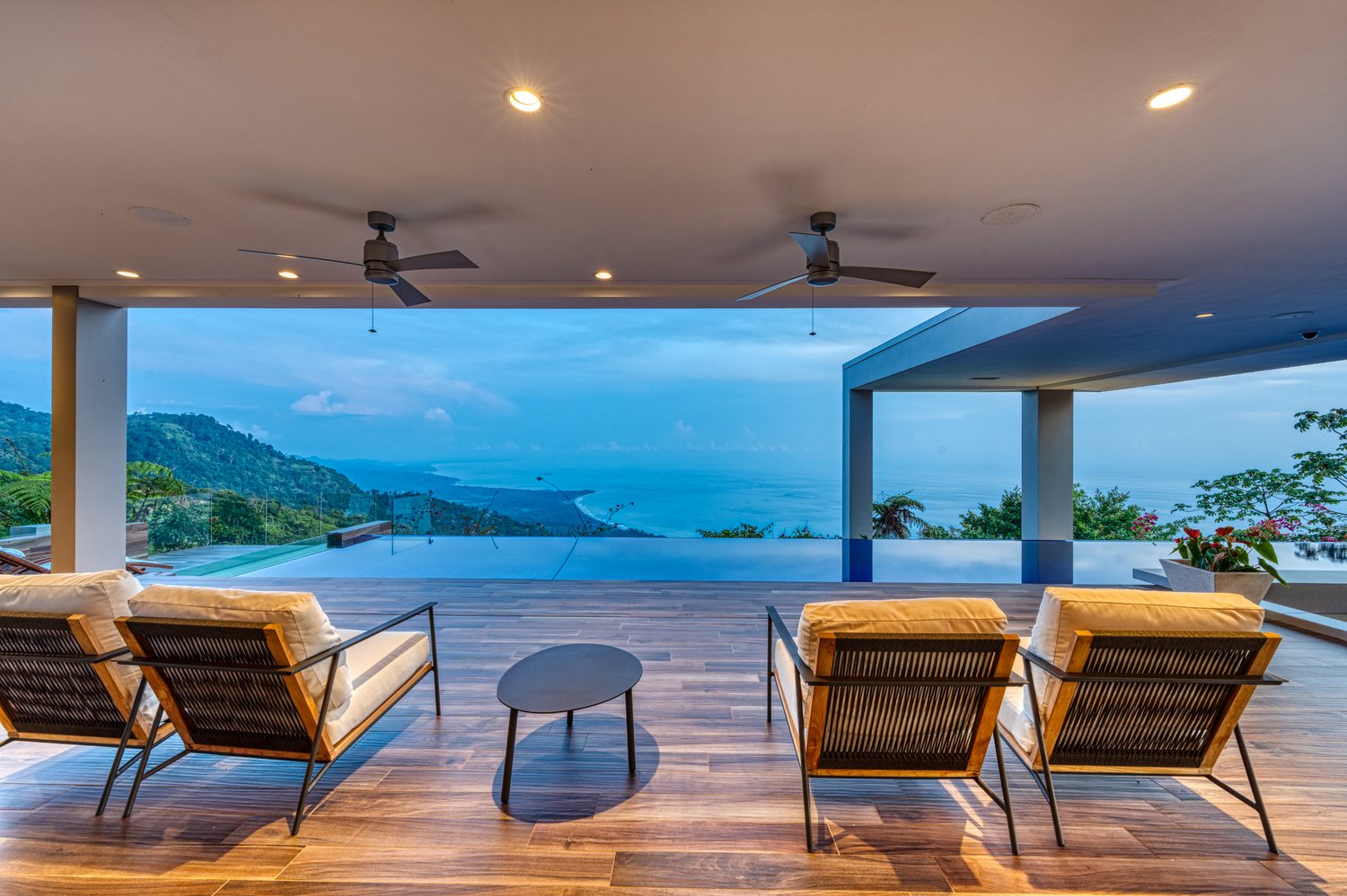 Ch&acirc;teau Montage &mdash; the covered terrace, the infinity pool and the coastline at dusk
