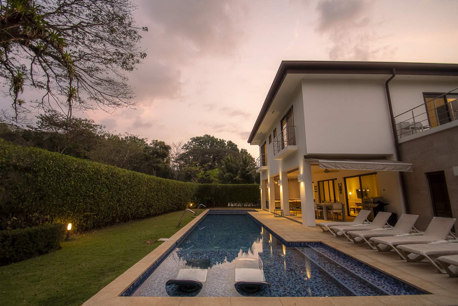 La Estancia &mdash; The house lit at dusk, the pool in the foreground