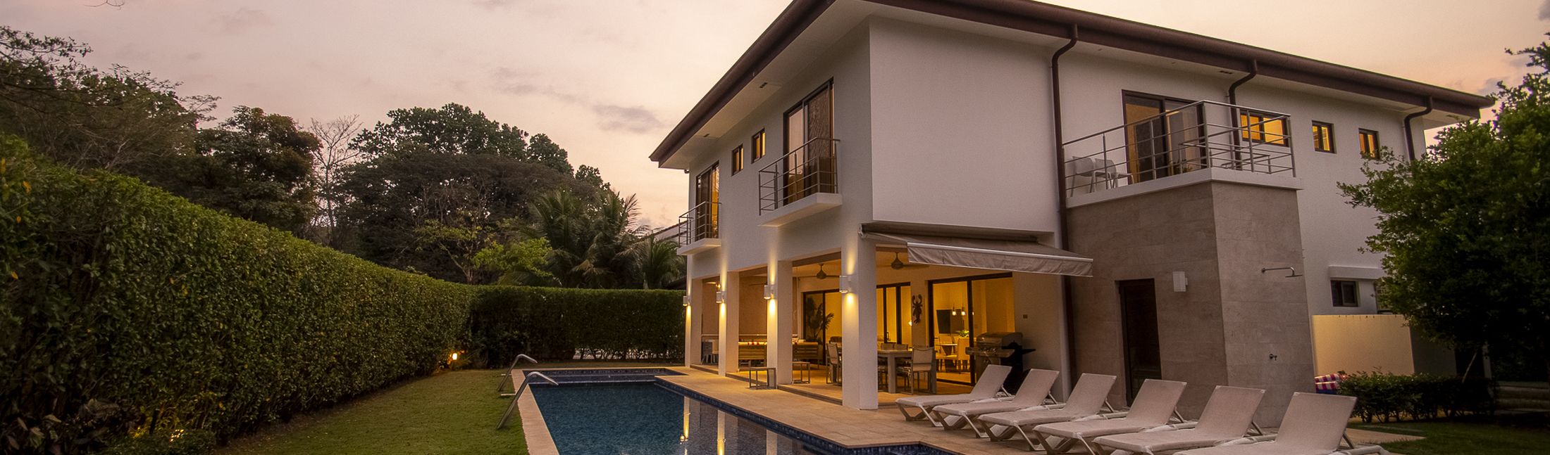 La Estancia at dusk, its lap pool and gardens in a gated community near Los Suenos Marina