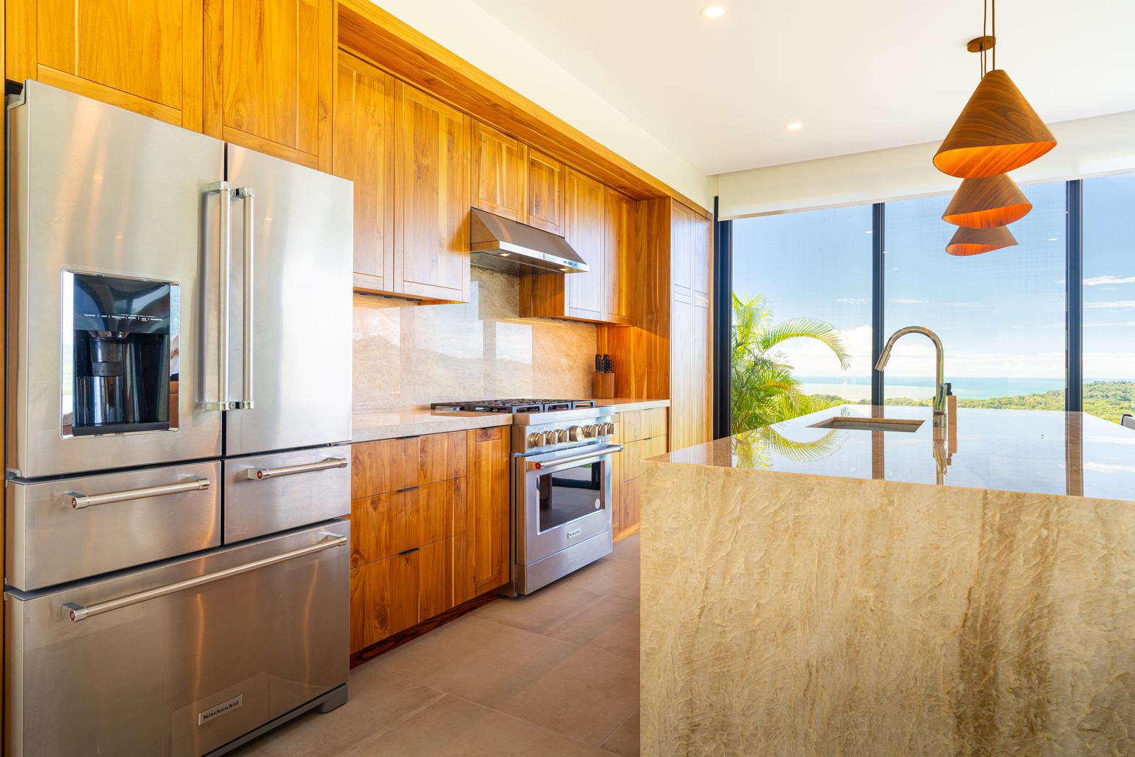 Modern Glass Estate &mdash; The kitchen island, topped in quartzite