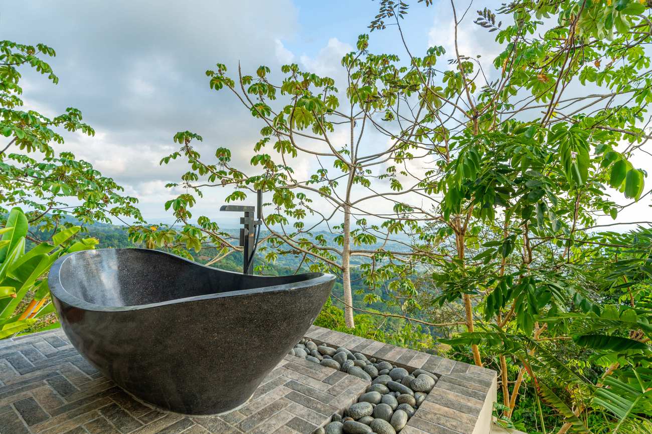 Sue&ntilde;o del Pac&iacute;fico &mdash; The imported Indonesian stone soaking tub, facing the mountains