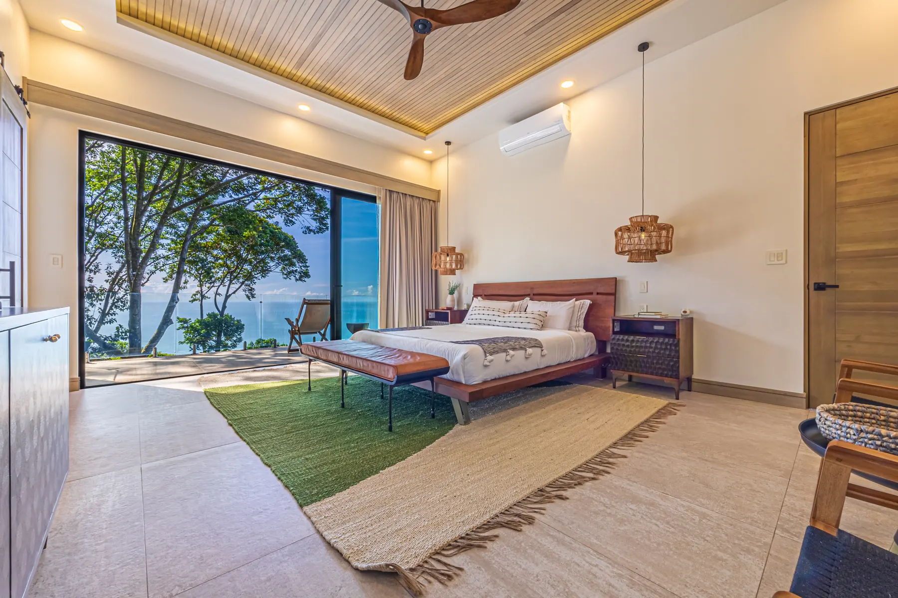 Villa San Martin &mdash; the primary suite, open to the lawn and the water