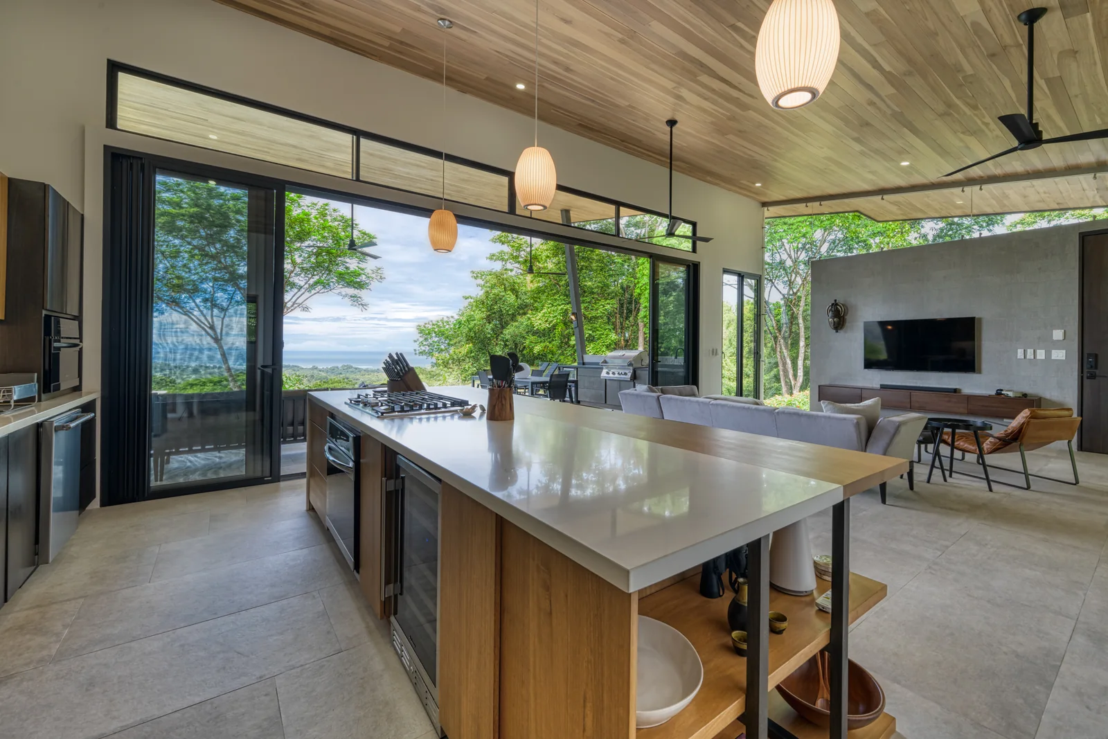 Vista Hermosa &mdash; the kitchen island, the room opening to the terrace and the ocean beyond