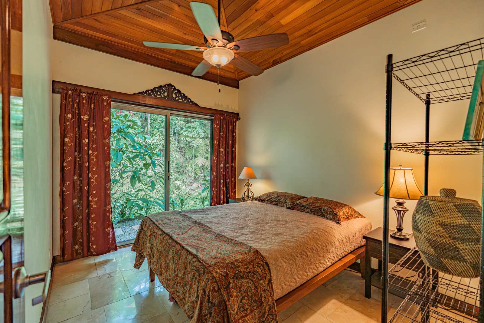 A guest bedroom with a wrought-iron four-poster bed